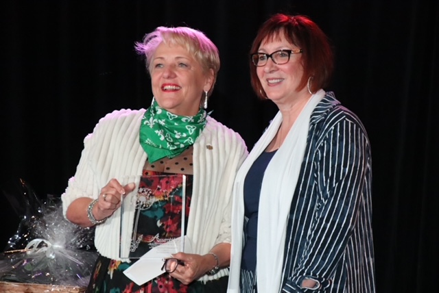 Sue Morin holding award.